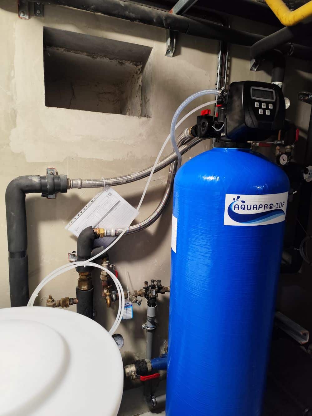 Adoucisseur AQUAPRO IDF – Maintenance et Installation Installation d'un adoucisseur d'eau professionnel sur mesure par AQUAPRO IDF dans un bâtiment tertiaire.